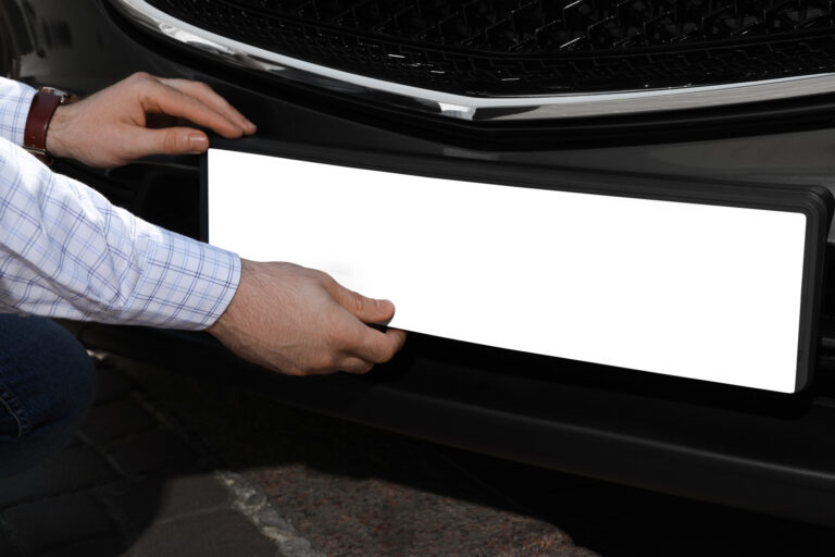 Number plate | Man installing vehicle registration plate outdoors, closeup. Mockup for design